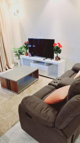 a living room with a couch and a tv at Diamond in Kileleshwa Othaya Rd in Nairobi