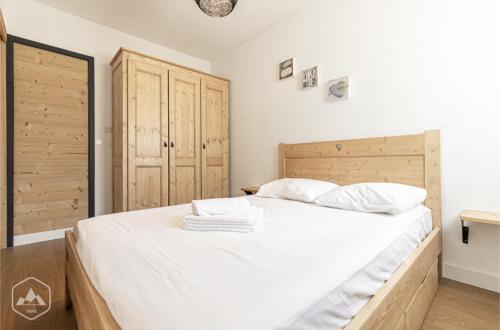 1 dormitorio con 1 cama grande con sábanas blancas en La Norma en Terrasse, en Villarodin-Bourget