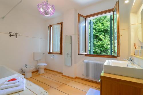 ein Bad mit einem Waschbecken, einem WC und einem Fenster in der Unterkunft Casa Cervade in Palazzo Del Maino