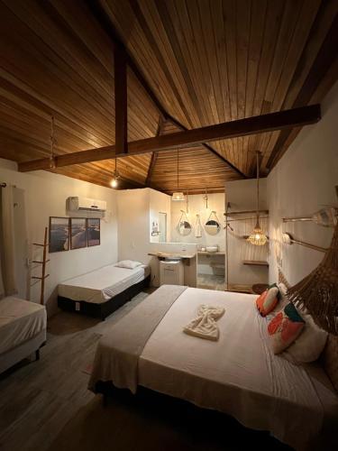 a large bedroom with two beds and a wooden ceiling at La Paz Village Atins in Atins