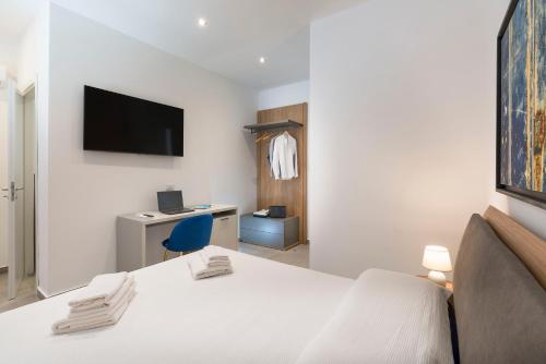 a bedroom with a bed and a desk with a tv at DipintodiBlu Charming House in Lampedusa