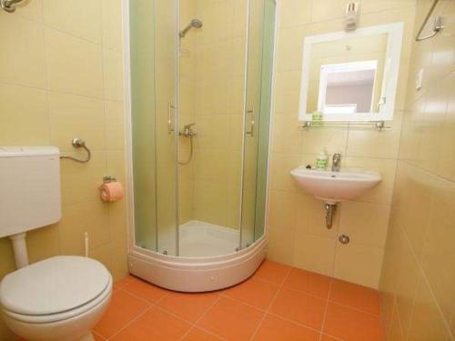 een badkamer met een douche, een toilet en een wastafel bij Apartman Nikolić 2 in Makarska