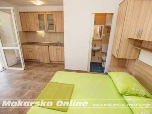 een keuken met een groen bed in een kamer bij Apartman Nikolić 2 in Makarska
