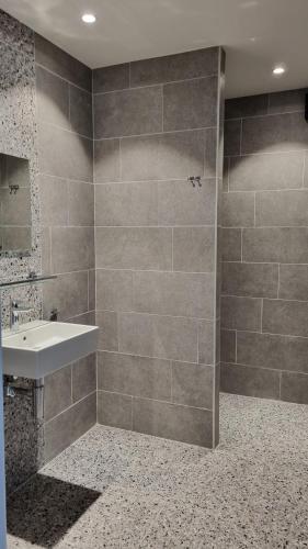 a bathroom with a sink and a shower at Boshovense Velden in Grobbendonk