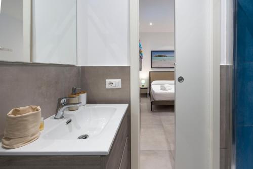 a bathroom with a sink and a room with a bed at DipintodiBlu Charming House in Lampedusa