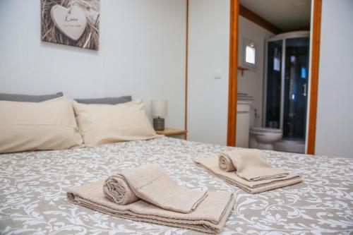 a bed with two towels sitting on top of it at Quinta do Sol in Lourinhã