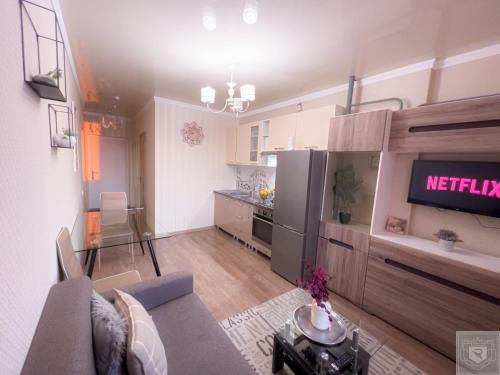 a kitchen and living room with a couch and a tv at RentHouse Apartments Little Paris in Chişinău