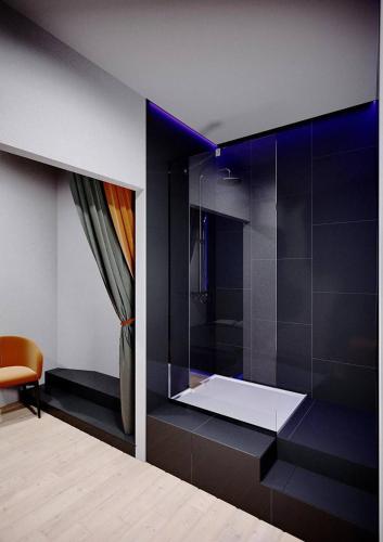 een kamer met een douche, een bed en een stoel bij Relax Mini Hotel Jindřišská in Praag