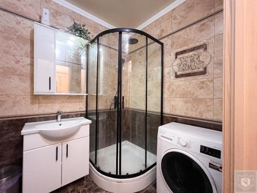 a bathroom with a shower and a washing machine at RentHouse Apartments Little Paris in Chişinău
