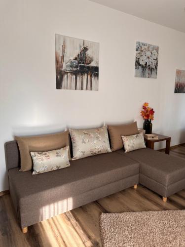 uma sala de estar com um sofá e pinturas na parede em Pensiunea CASA MOLDOVEANA em Piatra Neamţ