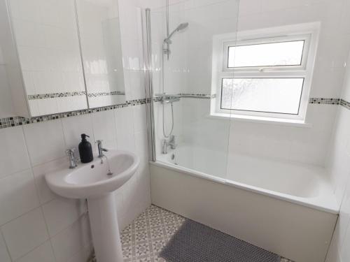 a white bathroom with a sink and a shower at Ty Beca in Clynderwen