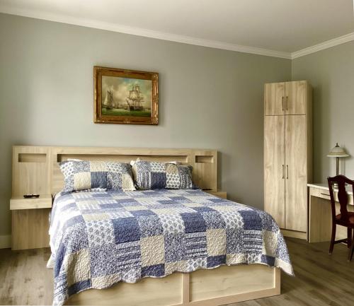 a bedroom with a bed with a blue and white comforter at Lunenburg Arms Hotel in Lunenburg