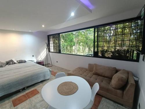 a bedroom with a bed and a couch and a table at Apartamento campestre LOFT con jacuzzi en San Lucas, El Poblado in Medellín