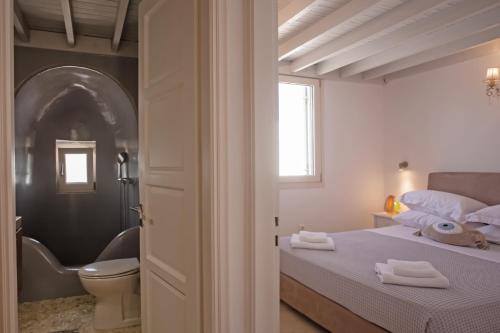 ein Schlafzimmer mit einem Bett und ein Badezimmer mit einem WC in der Unterkunft Villa Surfland in Ftelia