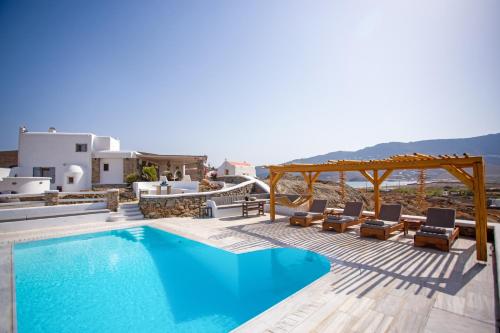 a villa with a swimming pool and a deck with chairs at Villa Surfland in Ftelia