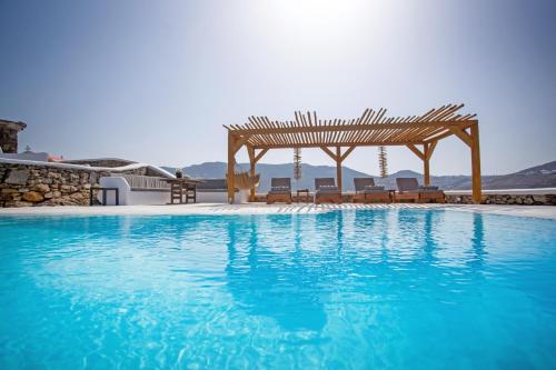 a swimming pool with a gazebo and blue water at Villa Surfland in Elia