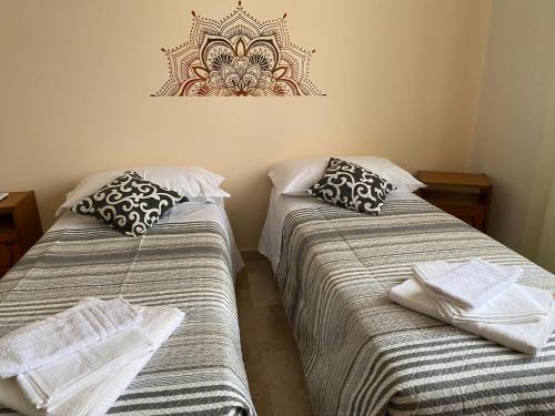 dos camas sentadas una al lado de la otra en una habitación en L'INCOGNITA, en San Nicolò dʼArcidano