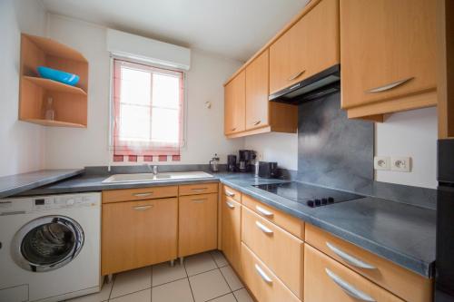 une cuisine avec un évier et une machine à laver dans l'établissement PARIS/DISNEY 50m2 - 10min de Disney - L'Aviateur, à Bussy-Saint-Georges