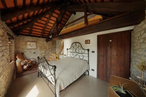 a bedroom with a metal bed in a stone wall at Country old stone house immerse in nature in Lequio Berria
