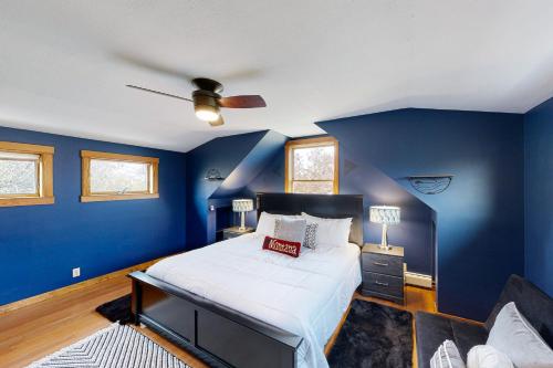 a blue bedroom with a bed and a ceiling fan at Bozeman Bungalow at Beall in Bozeman