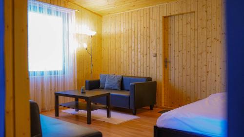 Zimmer mit einem Stuhl, einem Tisch und einem Fenster in der Unterkunft Ski House Jursport in Závažná Poruba