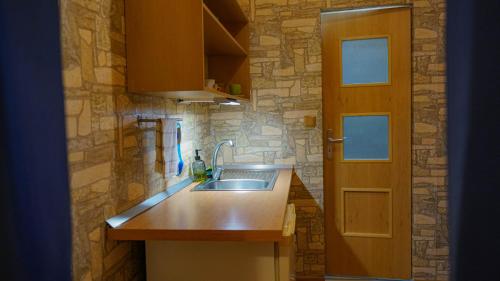 eine Küche mit einem Waschbecken und einer Steinmauer in der Unterkunft Ski House Jursport in Závažná Poruba