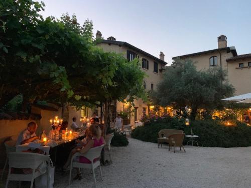 un gruppo di persone seduti a un tavolo in un cortile di Torre del Barbagianni - Castello di Gropparello a Gropparello