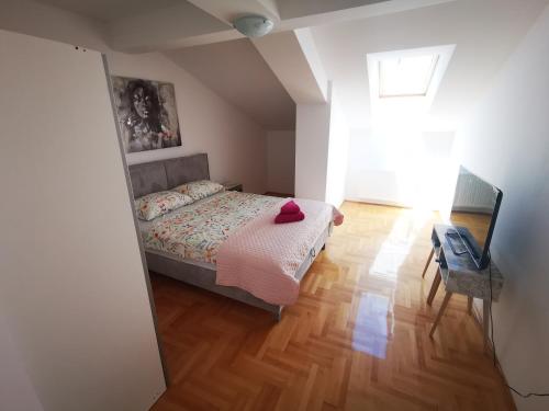 een slaapkamer met een bed met een rode hoed erop bij Riviera Apartments in Niš