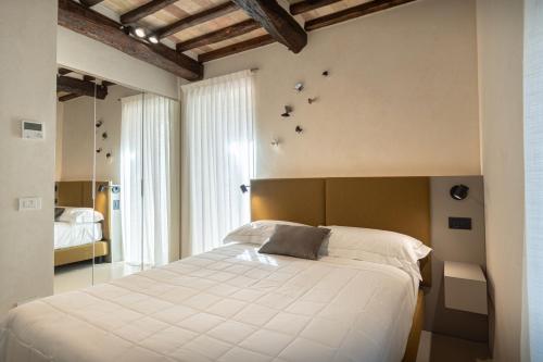 een slaapkamer met een groot wit bed met vogels aan de muur bij Xenios Assisi in Assisi