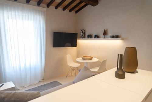 een witte woonkamer met een tafel en stoelen bij Xenios Assisi in Assisi