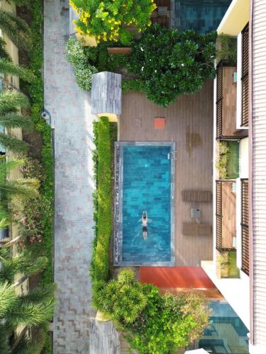 a person swimming in a swimming pool in a building at Palm Boutique Village - STAY 24H in Hoi An