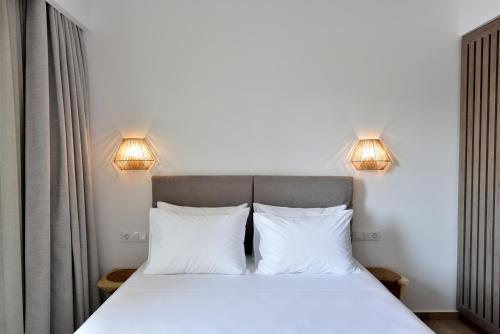 a bedroom with a bed with two white pillows at Anais Milos Suites in Adamas