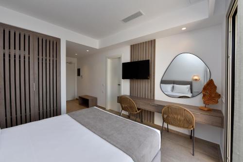 a hotel room with a large bed and a mirror at Anais Milos Suites in Adamas