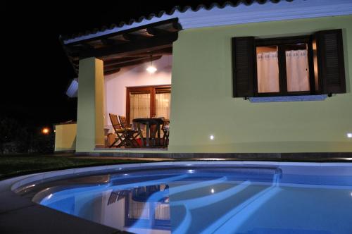 a swimming pool in front of a house at night at Villa Nadia con piscina privata Budoni in Tanaunella