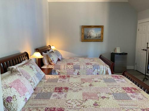 a bedroom with two beds and a picture on the wall at Lunenburg Arms Hotel in Lunenburg