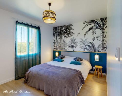 1 dormitorio con 1 cama grande con almohadas azules en Au petit bonheur, en Le Bugue