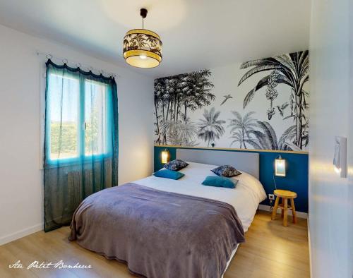 a bedroom with a large bed with blue pillows at Au petit bonheur in Le Bugue