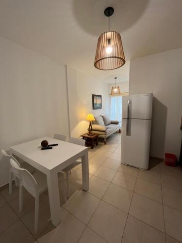 Naon في بوينس آيرس: مطبخ وغرفة معيشة مع طاولة بيضاء وثلاجة