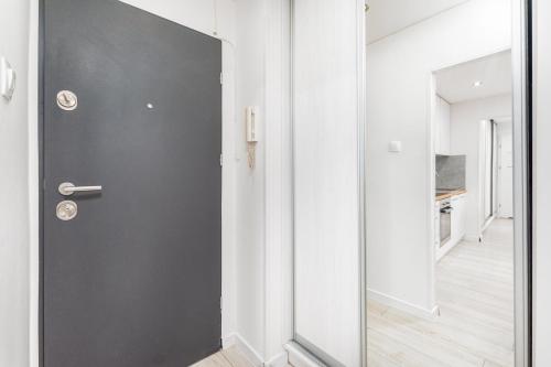 una puerta gris en una habitación blanca con un pasillo en Apartamenty Pańska by Your Freedom, en Varsovia
