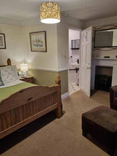 a bedroom with a bed and a living room with a fireplace at St Quintin Arms in Harpham