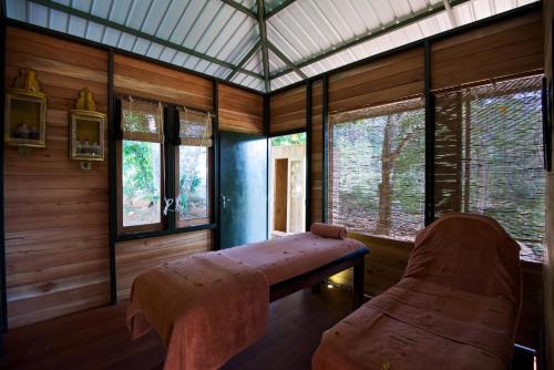 a room with a bench and some windows at Mountbatten Bungalow- Thema Collection in Kandy