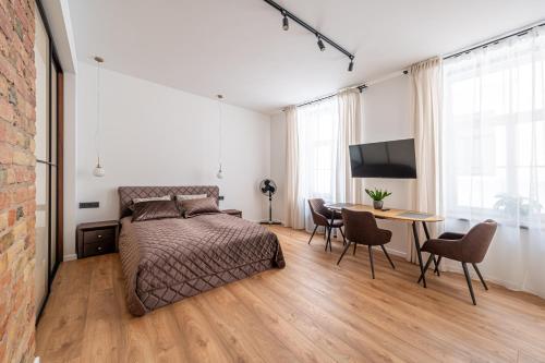 a bedroom with a bed and a table with chairs at Old town studio on Mucenieku street in Riga