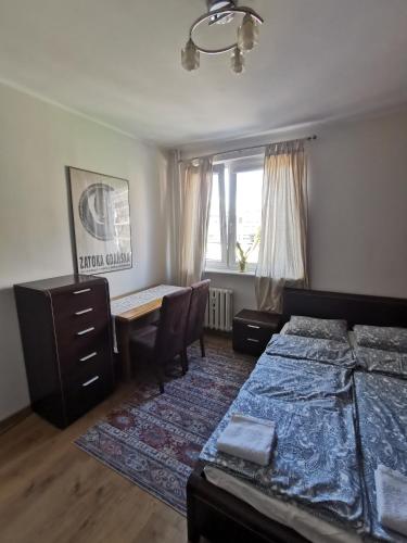 a bedroom with two beds and a desk and a window at Broniewskiego in Gdańsk