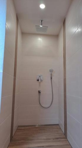 a bathroom with a shower with a hose on the wall at Ferienwohnung Natalie in Kaisersesch