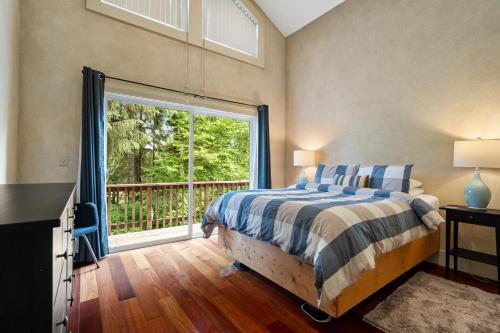 um quarto com uma cama e uma grande janela em Stylish Cabin em Orick