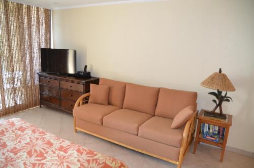 a living room with a couch and a television at Mahana Resort 612 in Kahana