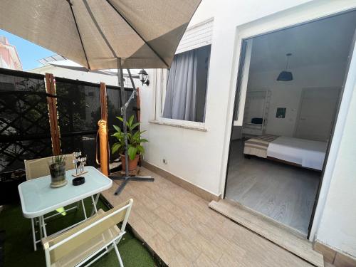 eine Terrasse mit einem Tisch und einem Sonnenschirm auf dem Balkon in der Unterkunft DMC - Alloggio Turistico in Anzio