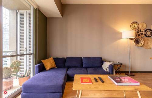 a living room with a blue couch and a table at Casa Vive Grand by Kukun in Mexico City