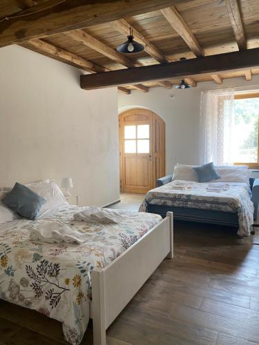 a bedroom with two beds and a wooden ceiling at Agriturismo Il Mulino della Rocca in Berceto