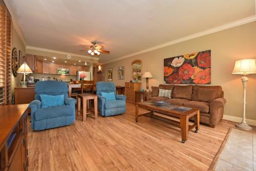 a living room with a couch and chairs and a table at Hale Mahina B101 in Kahana